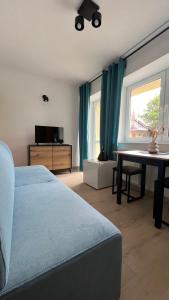 um quarto com uma cama, uma mesa e uma janela em Kraken-pokoje gościnne em Krynica Morska
