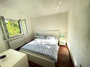 a small bedroom with a bed and a window at Welcoming House in Poljica with Private Pool in Kruševo +87 photos