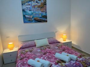 una camera con un letto con due lampade e un quadro di B&B Volì Club a Siderno Marina