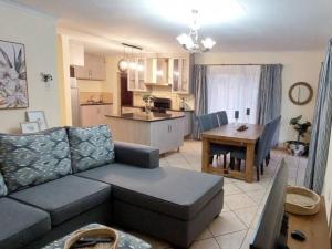 uma sala de estar e cozinha com um sofá e uma mesa em B&O's Place em Pretoria
