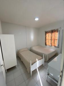 1 dormitorio con 2 camas, mesa y ventana en Departamento Pia en San Rafael
