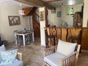 cocina y sala de estar con mesa y sillas en Le Clos du Val à Loup en Bénarville