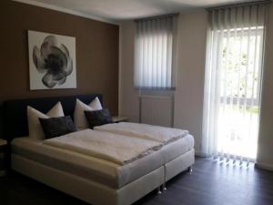 a bedroom with a large bed and two windows at HD City Apartments in Heidelberg