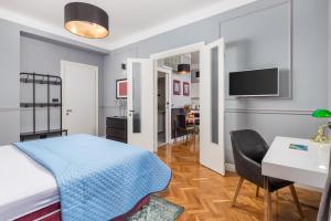 a bedroom with a bed and a table and a desk at apartment Tiziano-Belveder with private garage in Rijeka