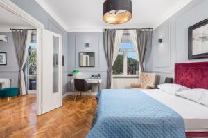 a bedroom with a bed and a desk and windows at apartment Tiziano-Belveder with private garage in Rijeka