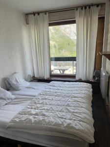 a bedroom with a large bed with a window at Tignes le Lac - Appartement au pied des pistes in Tignes