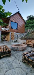 a building with a fire pit and benches in front of it at Shato Maxuntseti in K'veda Bzubzu