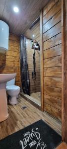 a bathroom with a toilet and a shower with wooden walls at Chateau Maxuntseti in K'veda Bzubzu