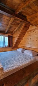 a large wooden bed in a room with wooden ceilings at Shato Maxuntseti in K'veda Bzubzu