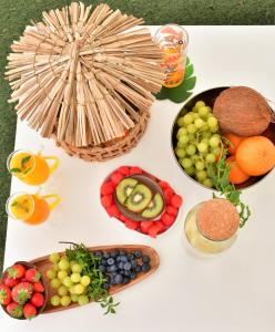 una mesa blanca cubierta con tazones de frutas y hortalizas en Kiwidestiny Alicante, en San Juan de Alicante