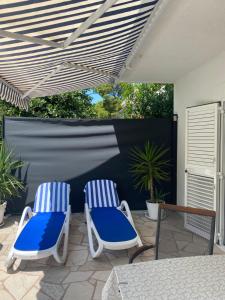 two blue and white chairs sitting on a patio at Apartmani Igor in Makarska