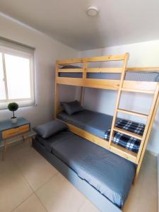 a bedroom with two bunk beds and a window at Apartasol confortable cerca al parque del café! in La Tebaida