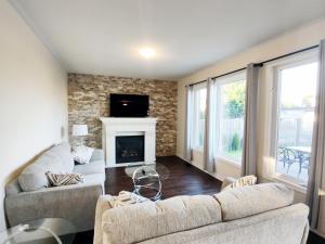 sala de estar con 2 sofás y chimenea en Home Pearl B&B en Cataratas del Niágara