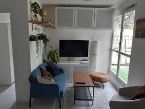 a living room with a blue couch and a tv at Bel appartement avec Terasse Proche Gare in Cergy