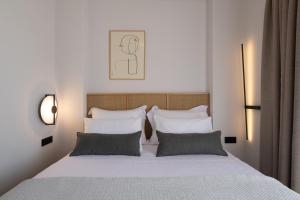 a bedroom with a bed with white sheets and pillows at Sun rise Villas ammouliani in Ammouliani