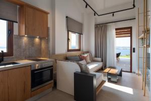 a kitchen and living room with a couch and a table at Sun rise Villas ammouliani in Ammouliani