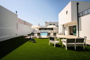 a yard with chairs and a table and a pool at Villa Serra Mar in São Martinho do Porto