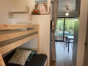 Cette chambre comprend 2 lits superposés et une table. dans l'établissement Studio Bandol 4 couchages centre ville vue mer garage, à Bandol