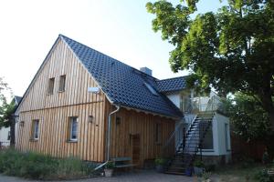 une grande grange en bois avec un toit en métal dans l'établissement Haus Jaeschke Appartement Charlotte, à Vetschau/Spreewald