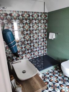 La salle de bains est pourvue d'un lavabo blanc et d'une douche. dans l'établissement Hotel & Apartments " Perpoin ", à Saluces