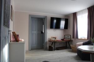a living room with a television on the wall at Haus Jaeschke Appartement Charlotte in Vetschau