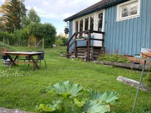 um jardim com uma mesa de piquenique e uma casa em Rustic Haven Bed and Breakfast near Klarälvsbanan and Swimming area em Munkfors