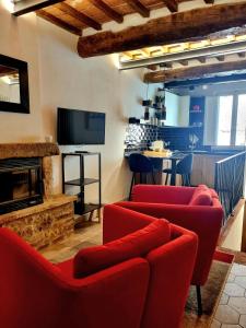 uma sala de estar com cadeiras vermelhas e uma lareira em OgniVolta em Pienza