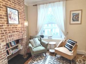 a living room with two chairs and a brick fireplace at Austin Terrace in Gorleston-on-Sea