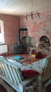 a living room with a brick wall and a wood stove at Niezapominajka in Kletno