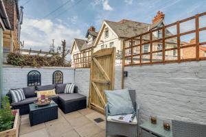 a patio with a couch and a wooden door at Austin Terrace in Gorleston-on-Sea