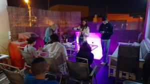 a group of people in a room with a woman on a stage at Aji Verde Hostel in La Serena