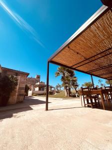 einen Pavillon mit zwei Holzstühlen unter einem blauen Himmel in der Unterkunft Masseria Casina Bellanova in Porto Cesareo