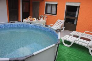 una piscina con sillas, una mesa y un patio en Casa do Campo, en Campo de Víboras