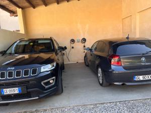 ソーナにあるAppartamento "Casa Vacanze Corte Ara Decima"の二台の車が隣同士のガレージに停められている