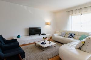 a living room with two white couches and a tv at Garden Mills Apartment in Lisbon +45 photos