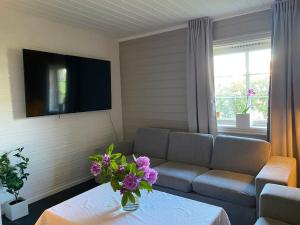 uma sala de estar com um sofá e uma mesa com flores em Martin Barstads veg 3b em Trondheim