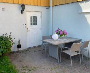 a table and chairs in front of a white door at Martin Barstads veg 3b in Trondheim