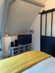 a bedroom with a bed and a flat screen tv at La Paulerie in Wacquinghen