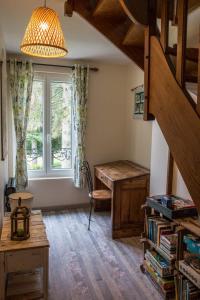 Cette chambre dispose d'un escalier, d'un bureau et d'une fenêtre. dans l'établissement Le Clos du Val à Loup, à Bénarville