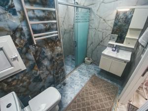 a bathroom with a shower and a toilet and a sink at Originative style of the apartment in Baku