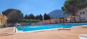 a large swimming pool with people in the water at Comme à la Maison in Saint-Paul-de-Fenouillet