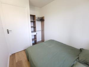 - une chambre avec un lit vert et une porte dans l'établissement Appartement proche plages, à Brancieux