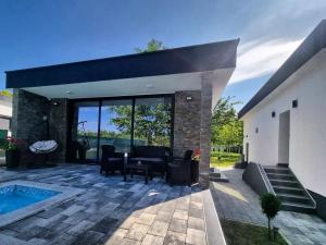 a patio with a table and chairs and a pool at Drinska Prica - Vikendica na Drini in Loznica