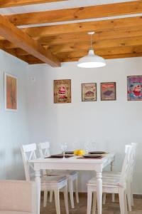 comedor con mesa blanca y sillas blancas en Ivi Villa, en Sivota
