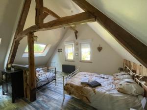 A bed or beds in a room at Le Clos du Val à Loup
