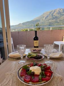 a table with a plate of food and a bottle of wine at Apartmant Villy in Bar