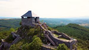 un castillo en la cima de una montaña con gente en él en Central Apartman, en Salgótarján