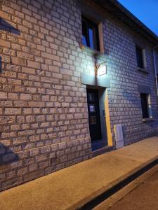 een bakstenen gebouw met een deur met een licht erop bij la halte des trois rivieres in Plichancourt