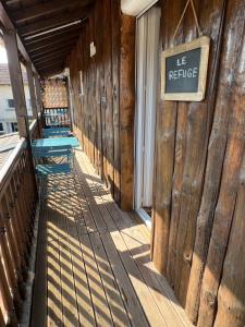 un bâtiment en bois avec un panneau indiquant le refuge dans l'établissement Les gîtes de la bergerie, à Meximieux