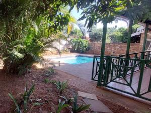 a swimming pool in a yard with a fence at B&O's Place in Pretoria +15 photos